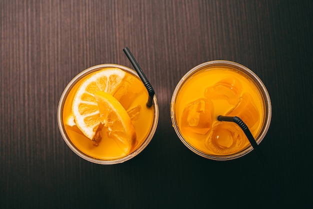 Top view photo of two glasses with lemonade over wooden background