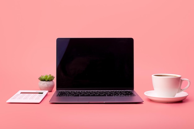 Top view photo white calculator cup of coffee and grey laptop on pink background Flatlay freelance