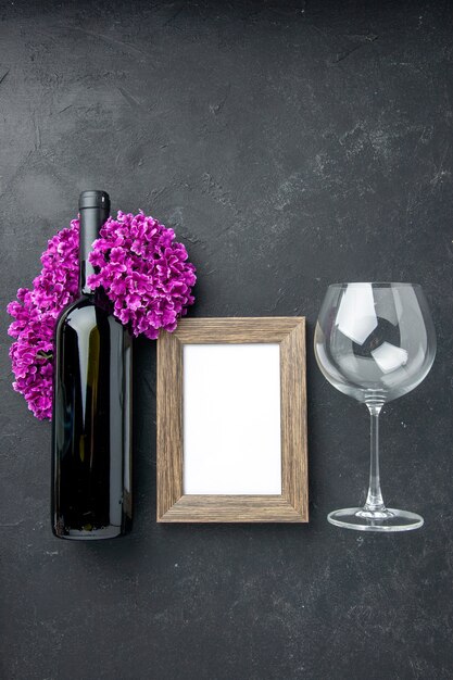 top view picture frame with bottle of wine and flowers on dark background feeling couple gift color marriage