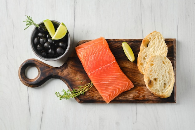 Top view of piece of fresh salmon steak with ciabatta and spicy herb sauce