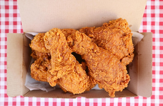 Top view of pile delectable golden brown fried chickens in a takeaway box