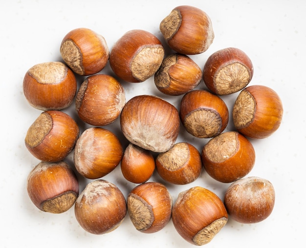 Top view of pile of whole hazelnuts on gray