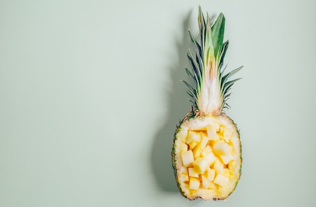 Top view of pineapple halves on green background