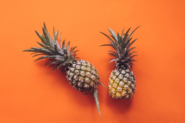 Top view of pineapples on a orange background