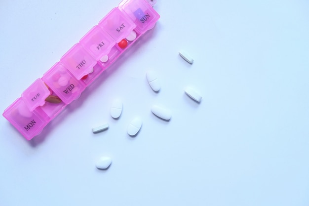 Top view of pink color pill box on white space