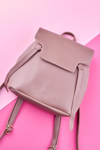 Top view of pink leather female backpack on pink\
background