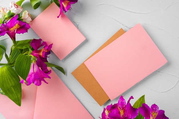 Top view of a pink paper letter and flowers with copy space