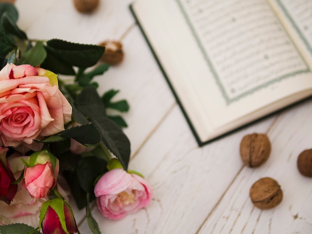 Photo top view pink roses next to quran