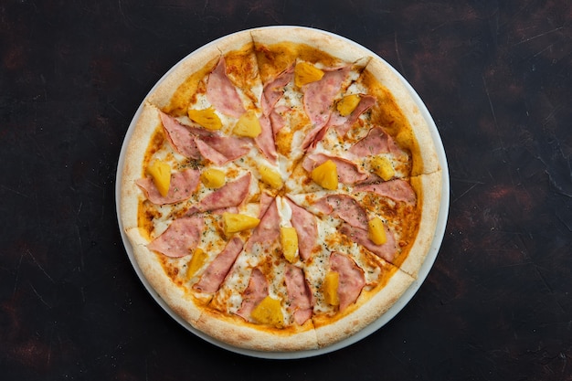 Вид сверху пиццы с куриной ветчиной и ананасом