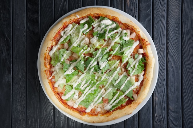 Top view of pizza wth pickled cucumber and salad