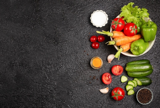 Top view plate full of vegetables on the black table