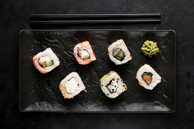 Top view plate with fresh sushi on desk