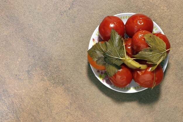 Верхний вид тарелки с маринованными помидорами, покрытыми специями