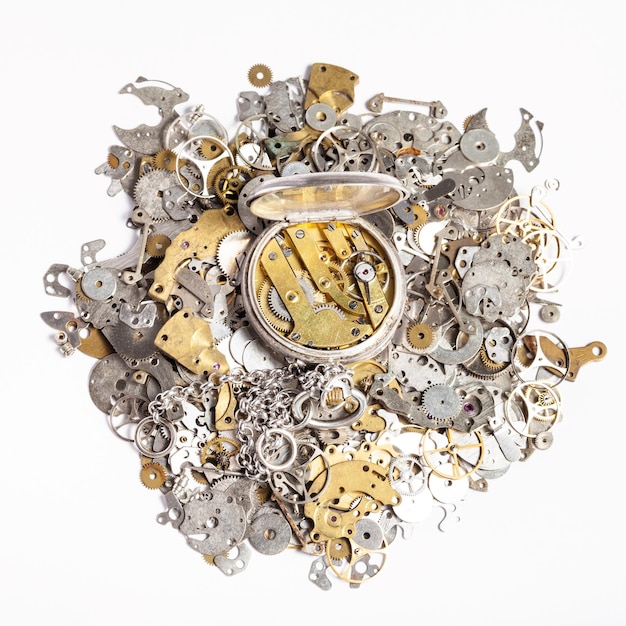 Top view of pocket watch on heap of spare parts