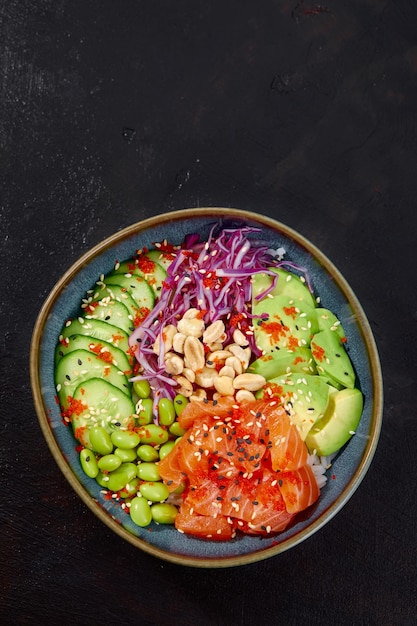 Top view on poke salad with tuna and green vegetable in the bowls on gray background Copy space