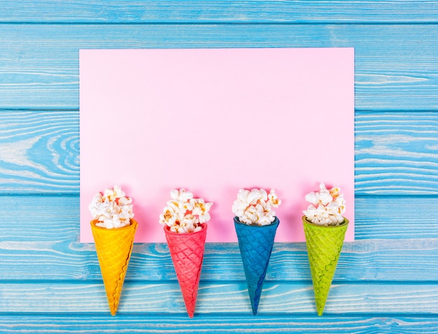 Photo top view of popcorn with caramel in waffle cones