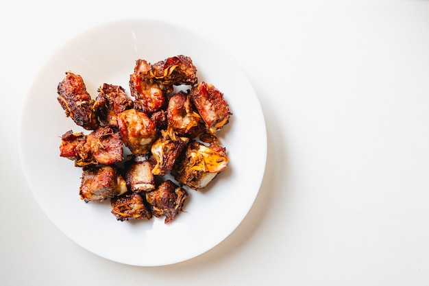 Top view of pork ribs fried with garlic and pepper. white background