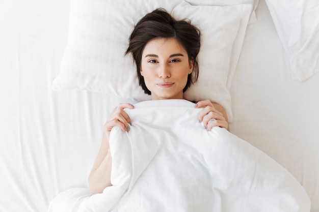 Top view portrait of a lovely young woman lying on a pillow