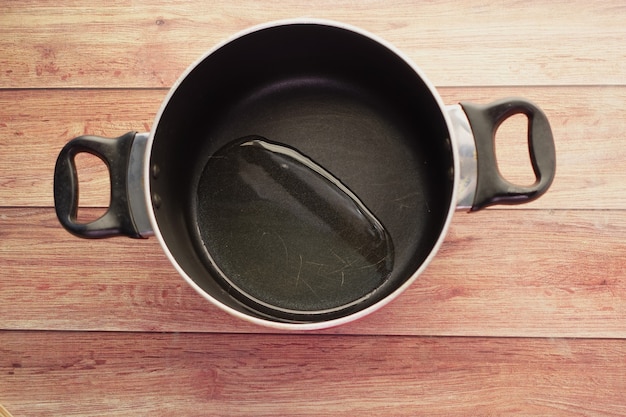 Top view of pouring vegetable oil into frying pan