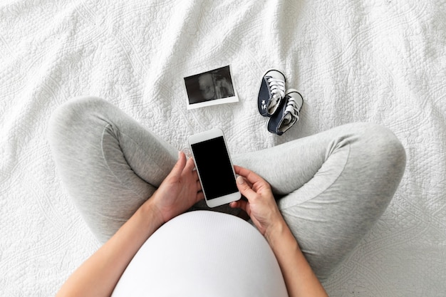 Photo top view pregnant woman checking her phone