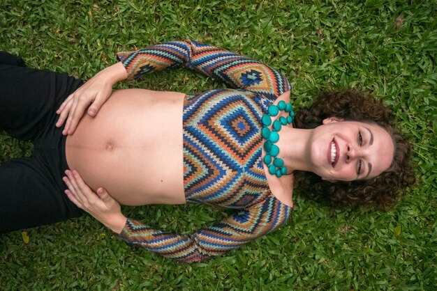 Top view of Pregnant woman laying in the grass.