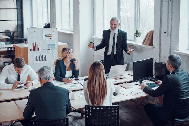 Top view of professional business expert presenting analytical report while working together with colleagues in the modern office