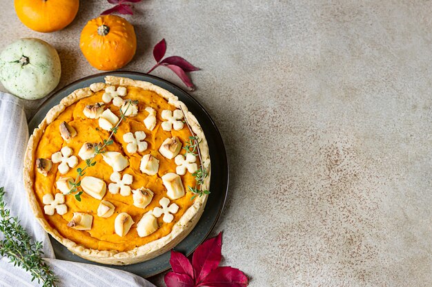 Top view of pumpkin tart or pie with feta cheese and thyme. Fall season concept.