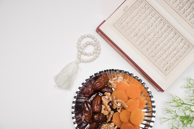 Photo top view quran and snacks on table