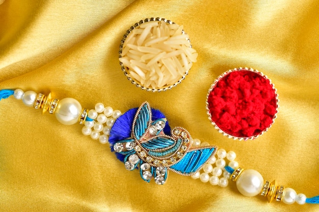 Top view of rakhi with roli chawal on golden background