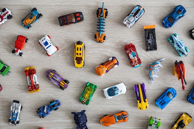 Photo top view random collection of model sport car toy hot wheels on wooden floor