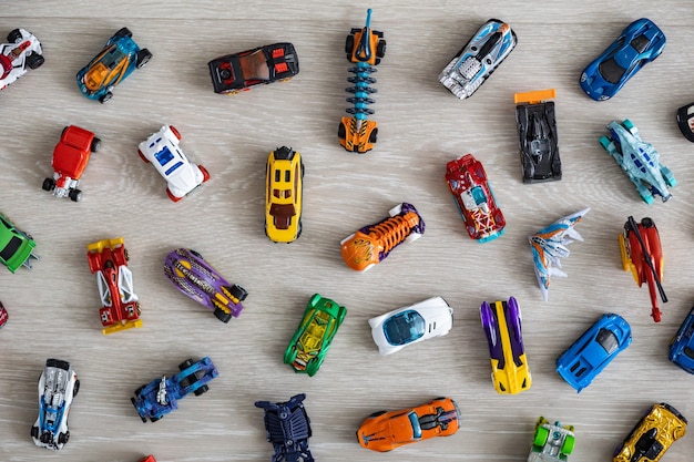 Top view random collection of model sport car toy hot wheels on wooden floor