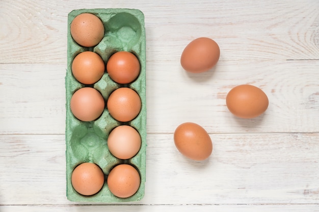 Top view of raw brown chicken eggs in egg carton box