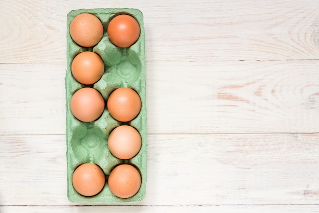 Top view of raw brown chicken eggs in egg carton box