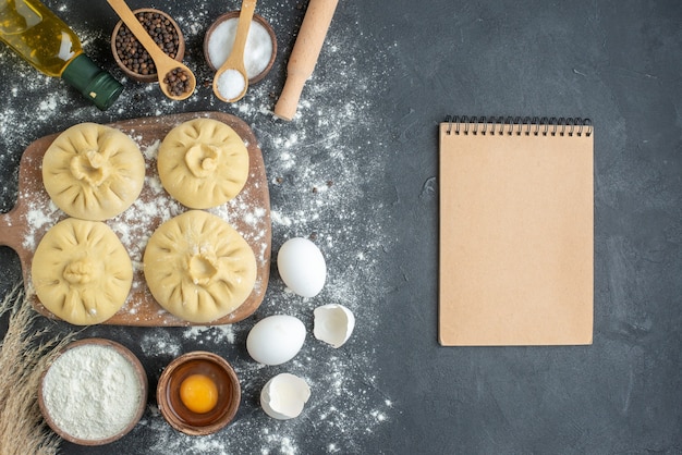 top view raw dumplings over cutting board with flour and eggs