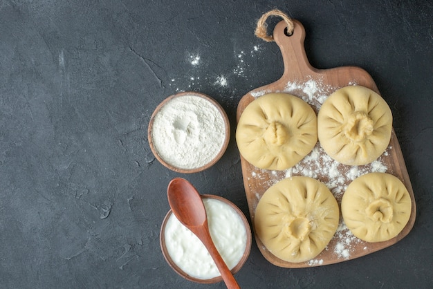 top view raw dumplings over cutting board with flour