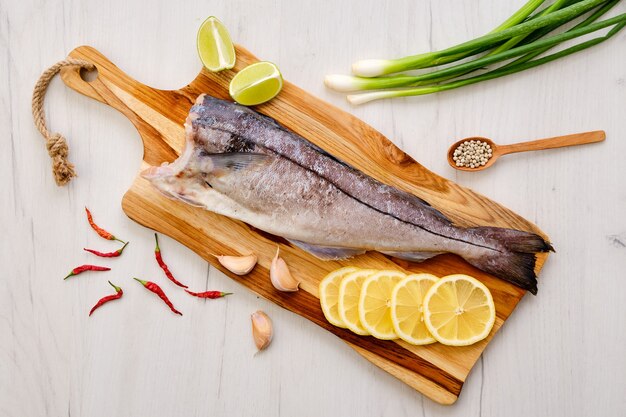 Top view of raw fresh haddock carcass on wooden cutting board