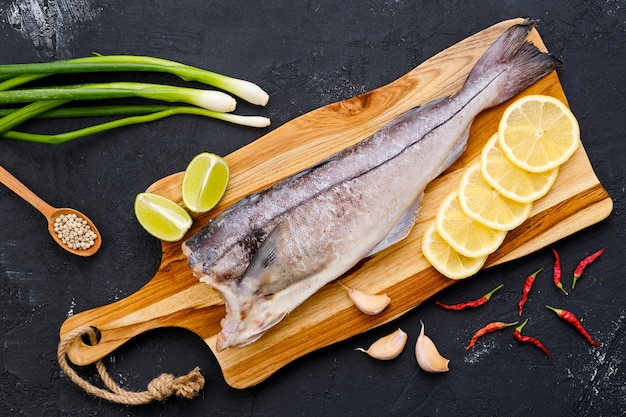 Top view of raw fresh haddock carcass on wooden cutting board