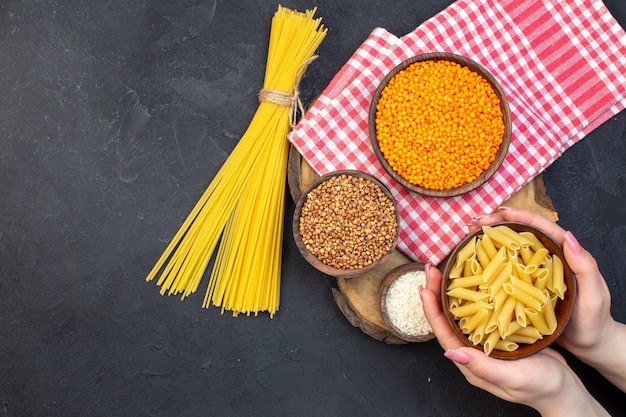 Vista dall'alto pasta italiana cruda con lenticchie e grano saraceno su sfondo scuro cibo cena colore cucina cucina lenticchie pasta oscurità pasta