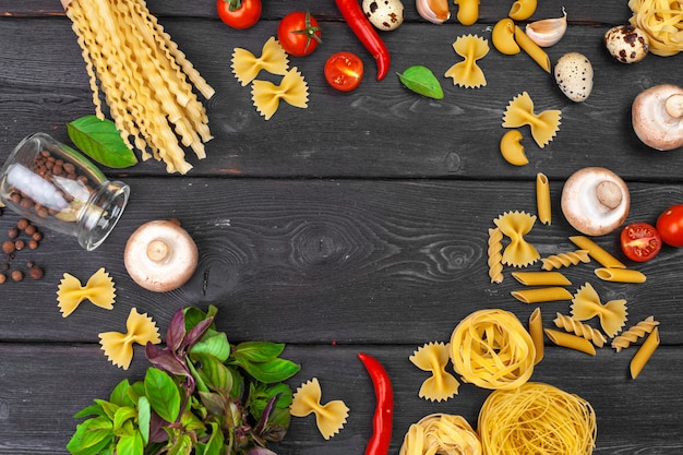 Top view of raw Italian pasta on wooden background