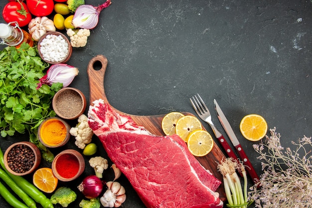 Fetta di carne cruda vista dall'alto con verdure e condimenti. colore del pasto salutare maturo