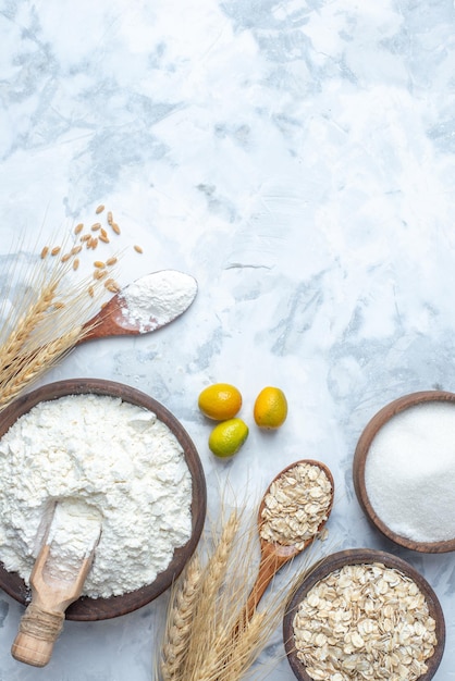 Top view of raw oatmeal flour in a brown bowl spikes and sugar on ice background