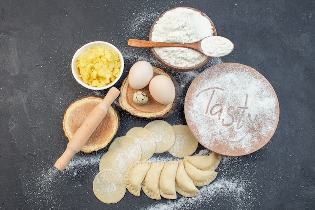 Foto vista dall'alto di patate crude hotcakes con uova purè di patate e farina su sfondo scuro pasto torta biscotto torta al forno cuocere la cottura dell'impasto