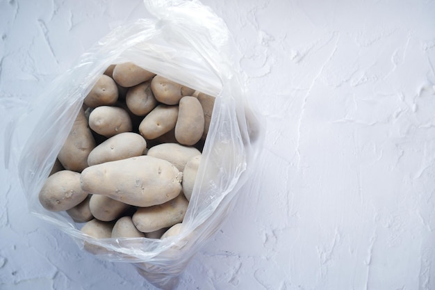 Top view of raw potato in a plastic bag on table