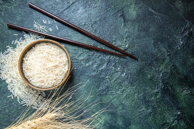 Top view raw rice inside plate on dark desk