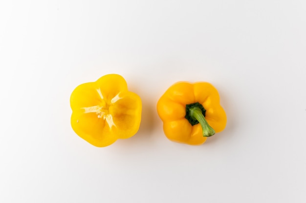 Top view raw yellow bell pepper sliced half on white table