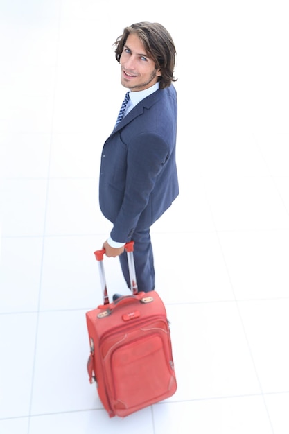 Photo top view and rearbusinessman with travel suitcase goes out