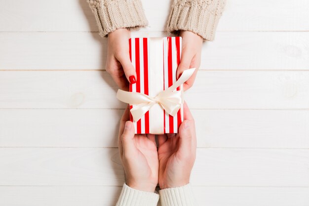 Top view of receiving a present on wooden background