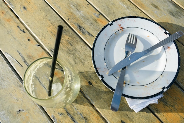 top view of recently used dirty dishes on table outside restaurant at sunset