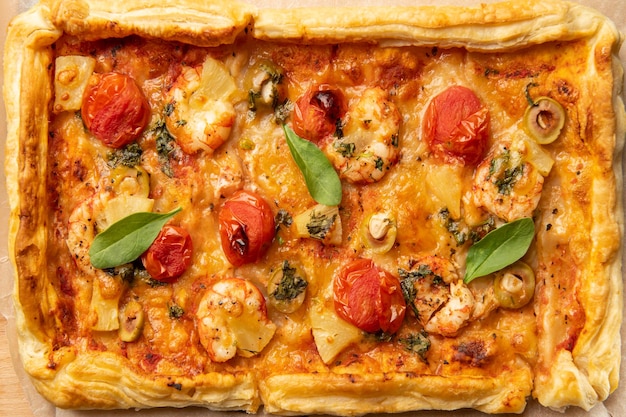 Top view of rectangular pizza with tomatoes and shrimps