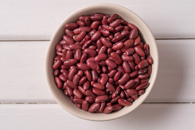 Top view red beans in a bowl over white wood